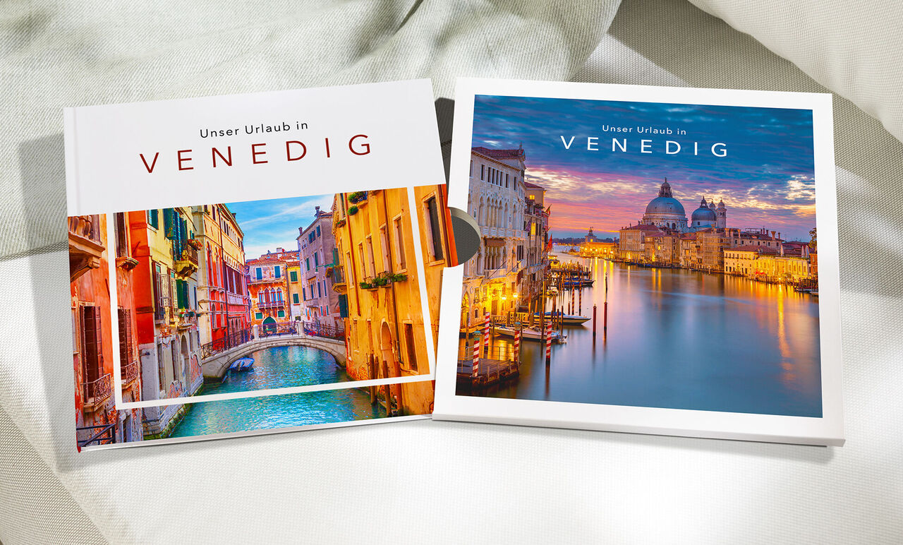 Ein CEWE FOTOBUCH Venedig mit farbenfrohen Stadt- und Kanalansichten herausgezogen aus einem Schuber