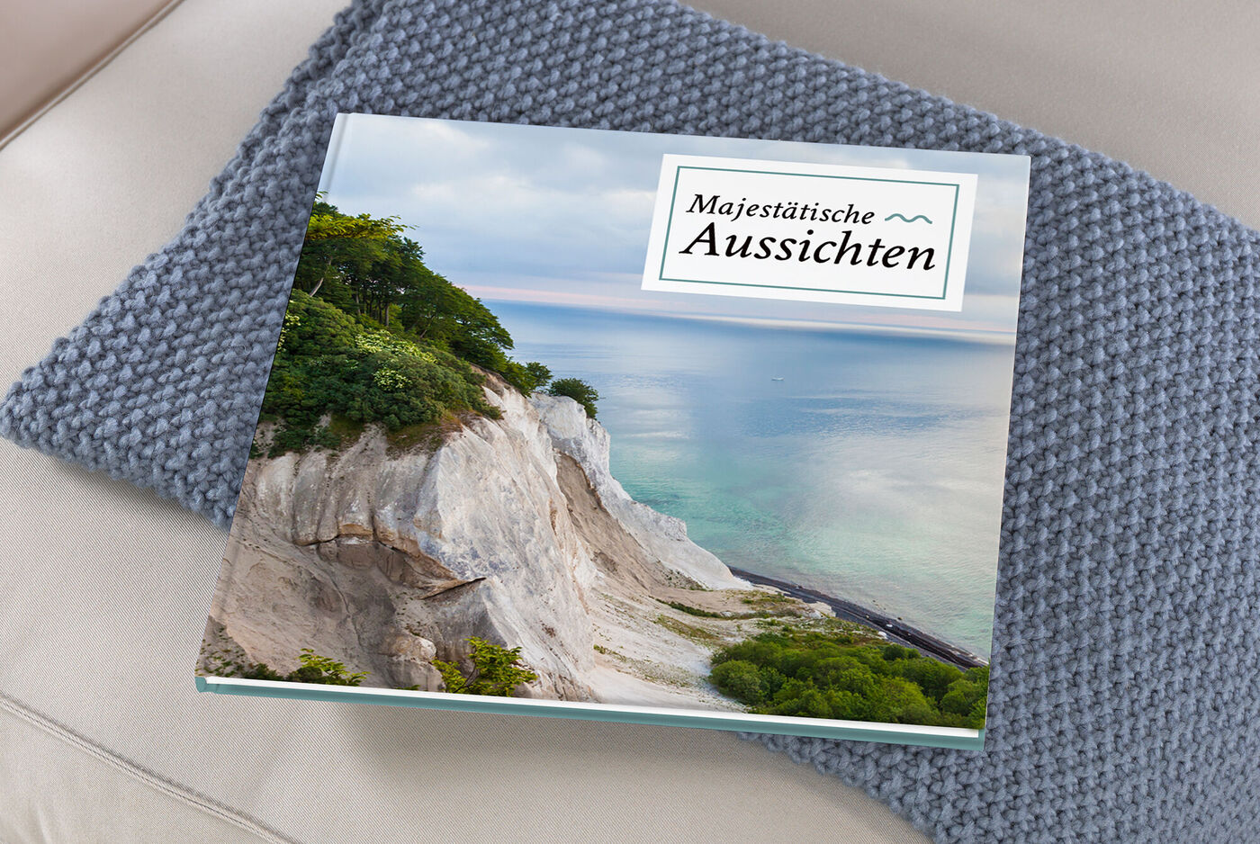 Fotobuch mit dem Titel 'Majestätische Aussichten' liegt auf einem hellen Kissen.