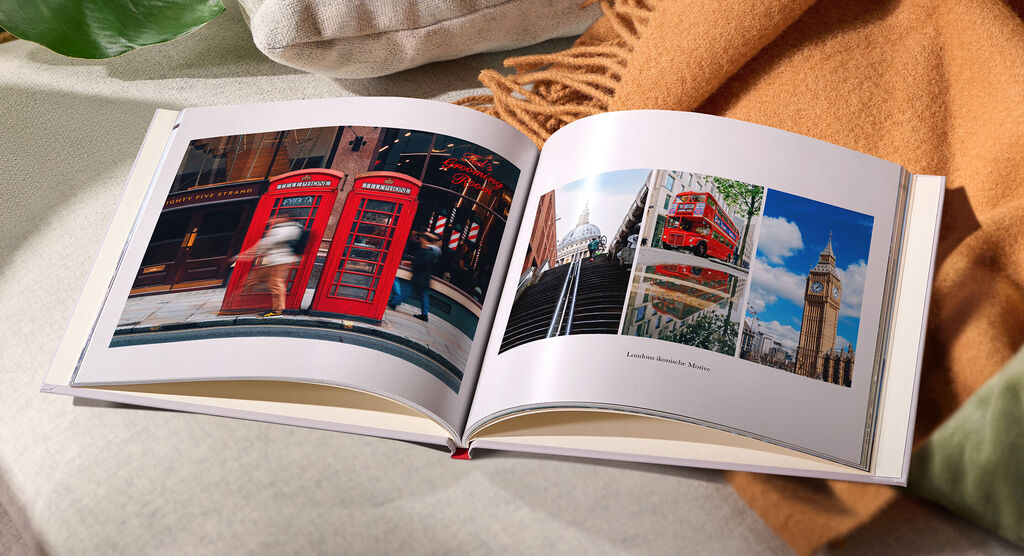 Geöffnetes CEWE FOTOBUCH mit Fotos aus London, darunter rote Telefonzellen und Big Ben.