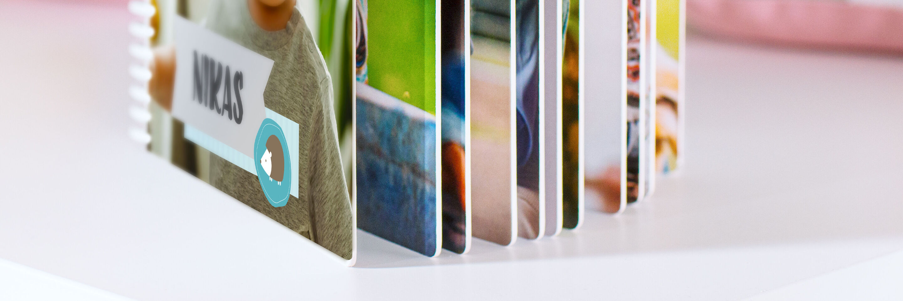 Ein CEWE Fotobuch ist aufgeschlagen mit bunten Seiten und persönlichen Fotos
