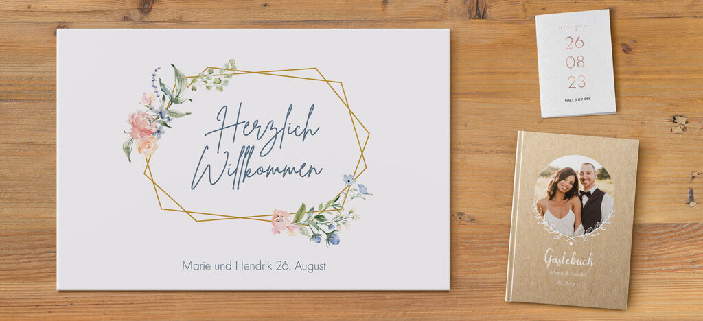 Ein liebevolles Willkommen auf einer Hochzeitskarte mit floralen Elementen in sanften Farben, das Datum ist angegeben.
