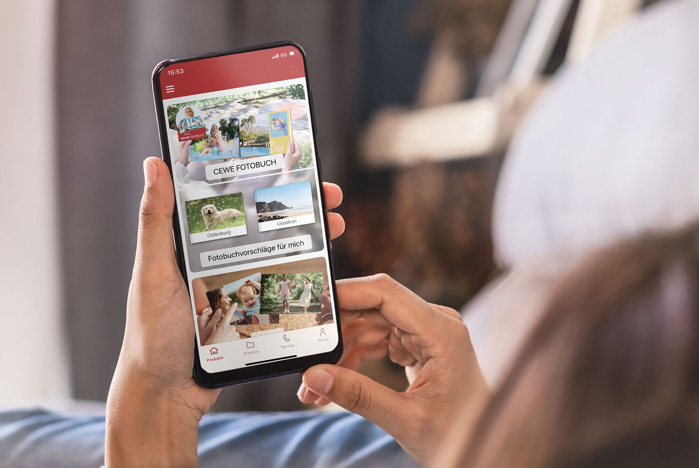 Person sieht auf ihr Smartphone mit der CEWE Fotobuch App
