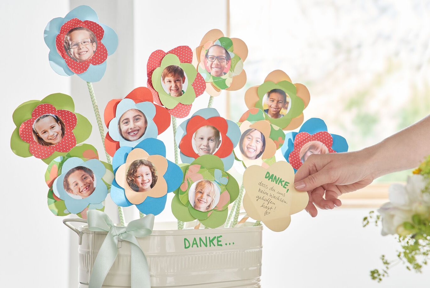 Bunte Papierblumen mit einem Danke-Text und einer personifizierten Karte in einer Vase