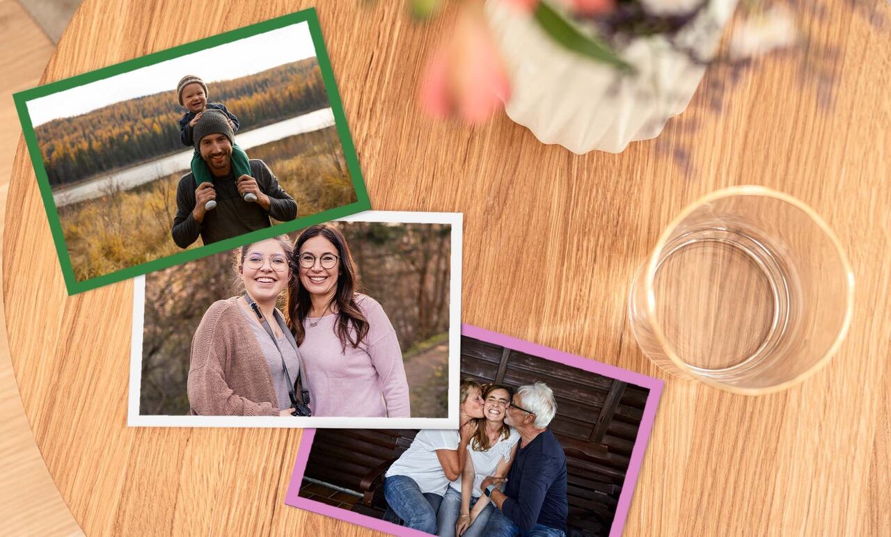 Drei Fotos auf einem Holztisch. Oben ein Bild mit einem Kind auf den Schultern eines Erwachsenen, im Hintergrund ein See. In der Mitte ein Foto von zwei Frauen im Freien und unten ein Bild von einer Gruppe Menschen mit Lächeln.