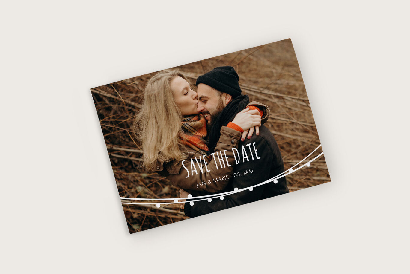 Paar mit liebevollem Blick auf Save-the-Date-Karte für Hochzeit.