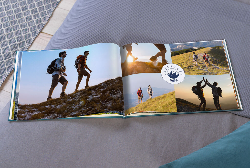 Ein offenes Fotobuch mit Wanderfotos auf einer Wiese. Es zeigt bewegende Momente von Freunden und Erinnerungen an schöne Zeiten.