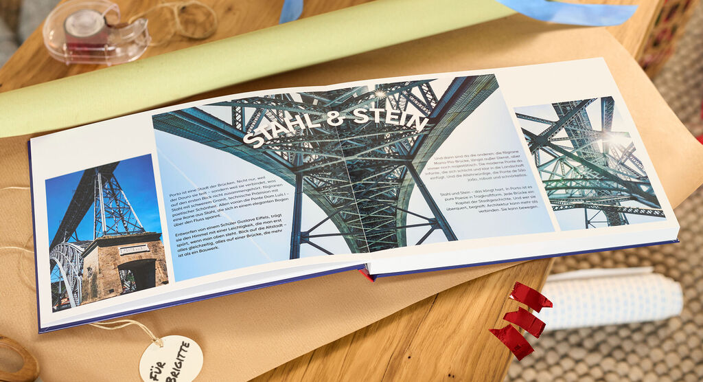 Offenes CEWE FOTOBUCH mit Fotos einer großen Stahlbrücke und dem Schriftzug Stahl und Stein.