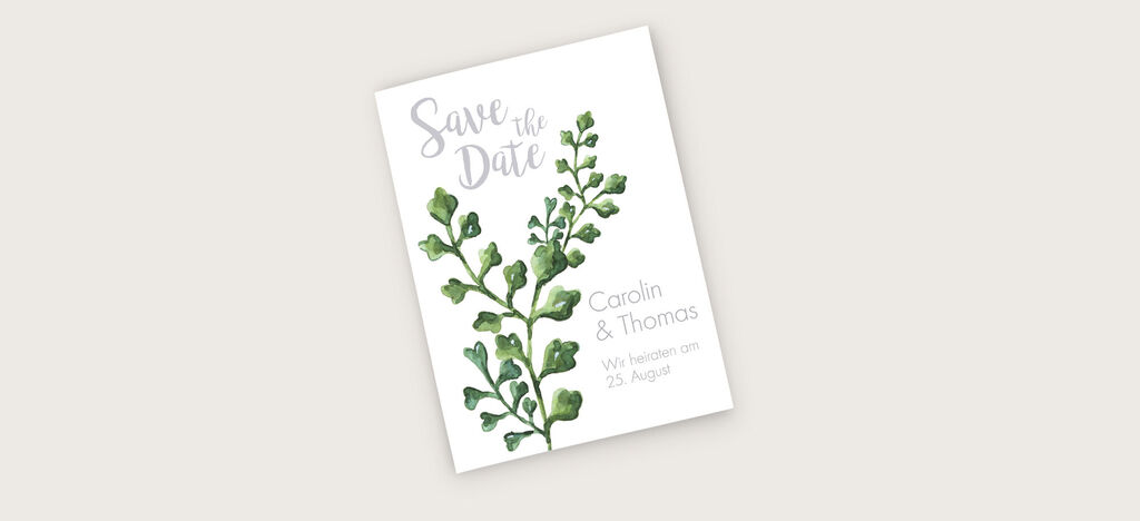 Ein Save-the-Date-Kartenmotiv mit grünen Blättern und den Namen Carolin und Thomas.