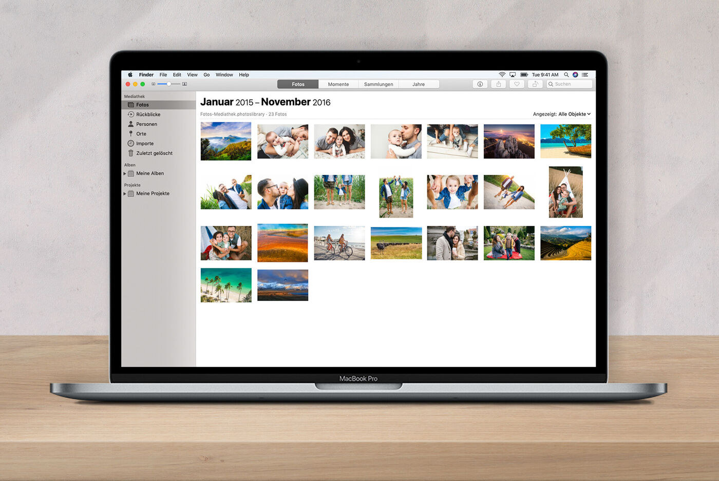 Laptop auf einem Holztisch zeigt eine Fotogalerie mit Urlaubsfotos und Glücksmomenten aus verschiedenen Monaten.