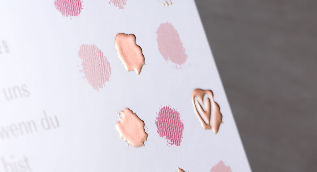 Farbenfrohe Farbkleckse und Lippenstiftabdrücke auf einer Karte