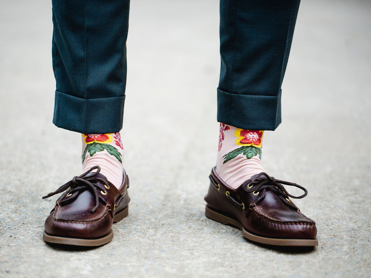 Mann trägt braune Schuhe mit bunten Socken