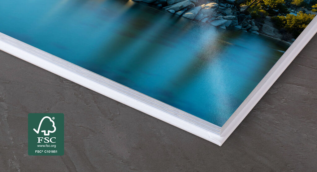 Detailaufnahme eines hochwertigen Fotobuchs mit glänzenden Seiten, das sanft auf einem Tisch liegt