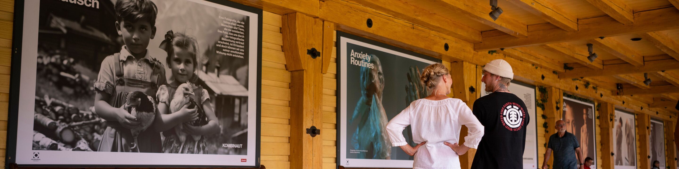 Ein Mann und eine Frau betrachten Fotos in einer großen Ausstellung.