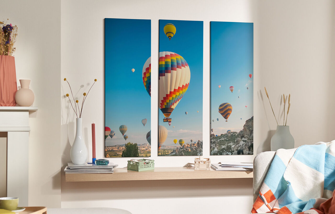 Bunte Heißluftballons schweben am blauen Himmel über Hügeln