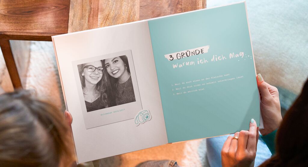 Ein offenes Fotobuch mit Bildern und dem Text 3 Gründe, warum ich dich mag.
