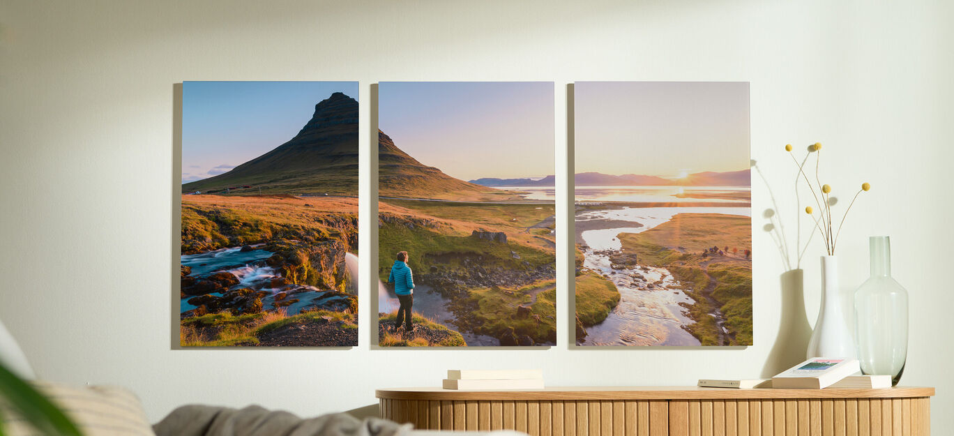Ein Mensch im blauen Jackett steht vor einer malerischen Landschaft mit Berg und Fluss, die in sanftem Licht erstrahlt.