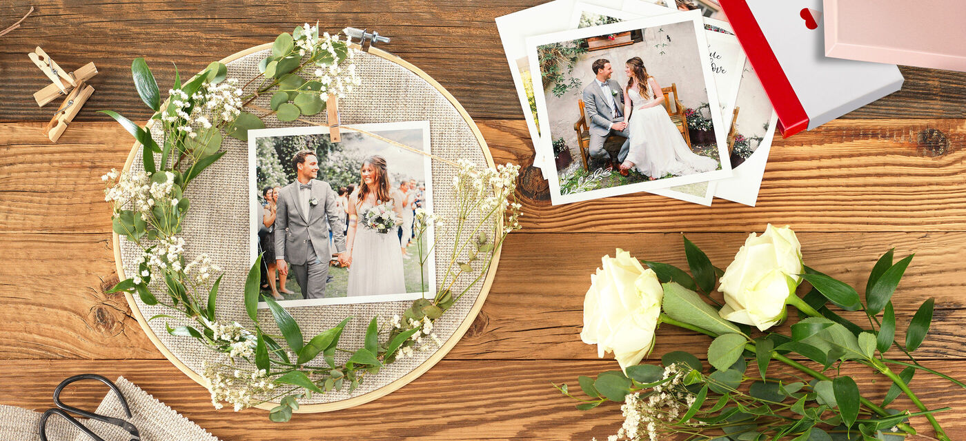 Hochzeitsfotos in einem dekorativen Arrangement mit Blüten und Bildern.