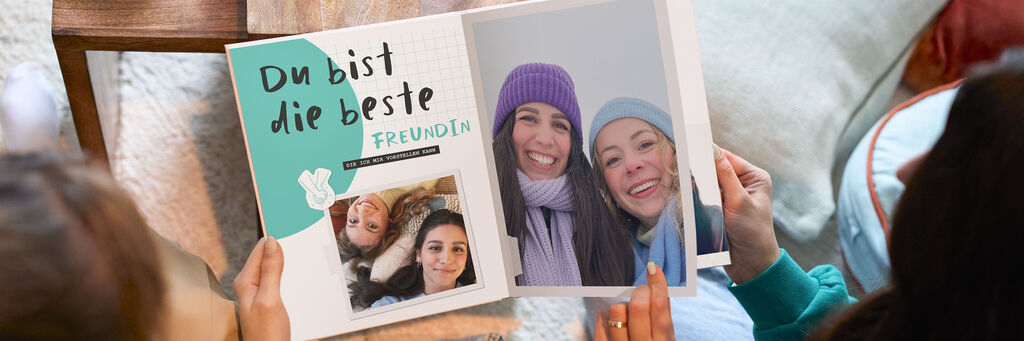 Eine Person zeigt ein liebevoll gestaltetes Fotobuch mit dem Titel 'Du bist die beste Freundin'.