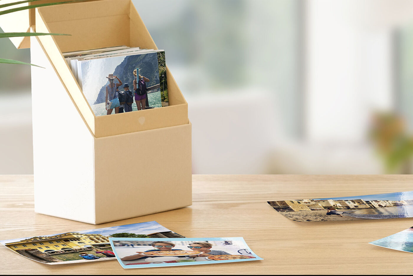 Eine dekorative Box mit Fotos und einigen Bildern, die auf einem Tisch im Vordergrund liegen.