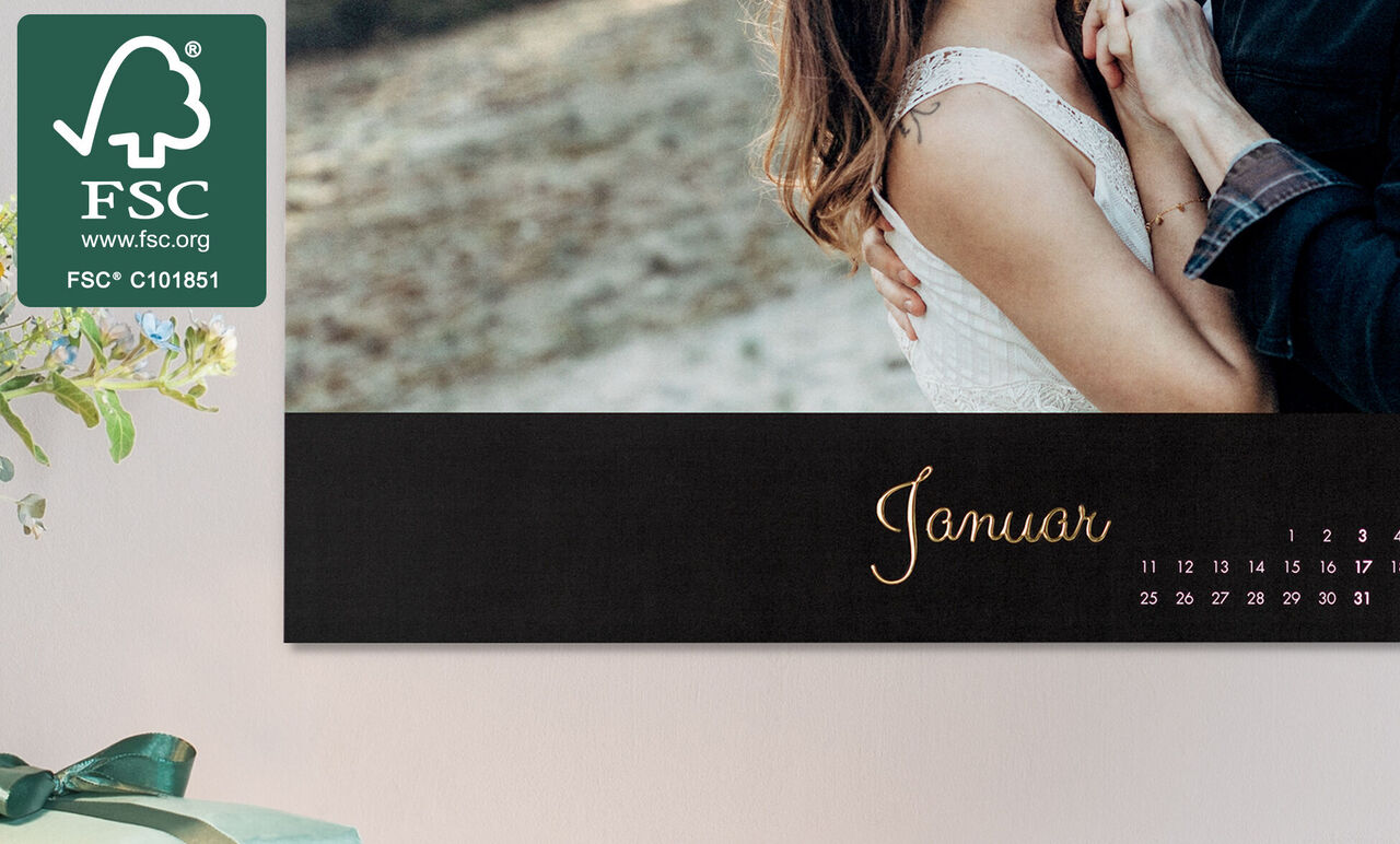 Kalenderblatt für Januar mit elegantem Design in Schwarz und goldener Schrift, zeigt ein Paar in inniger Umarmung