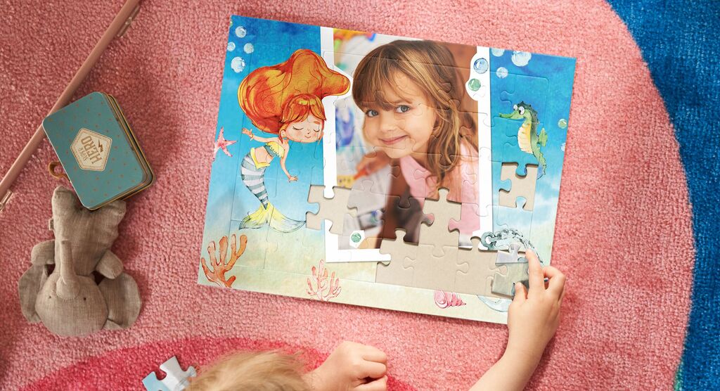 Ein Kind puzzelt mit einem liebevoll gestalteten Unterwasser-Motiv, umgeben von bunten Details.