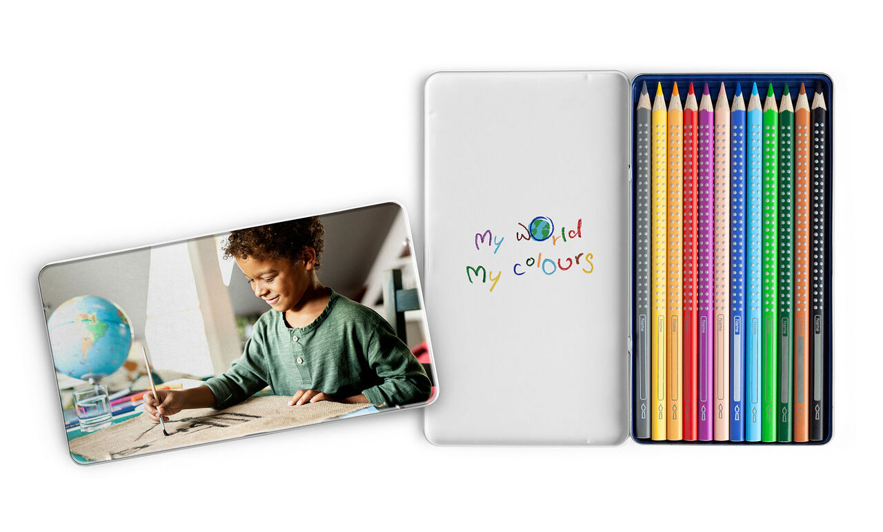 Ein Kind zeichnet mit bunten Stiften. Rechts sind viele Buntstifte und ein Notizbuch mit dem Titel "my world my colours" zu sehen.