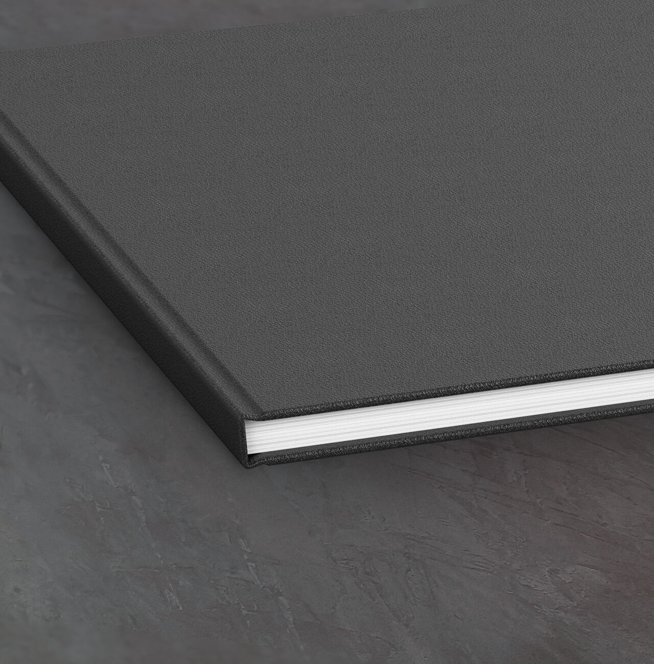Schwarzes Fotobuch mit weißem Seitenrand, auf einer schlichten Oberfläche