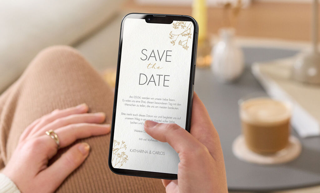 Eine digitale Safe the Date Karte in gold-weißem Design ohne Foto auf einem Handybildschirm.
