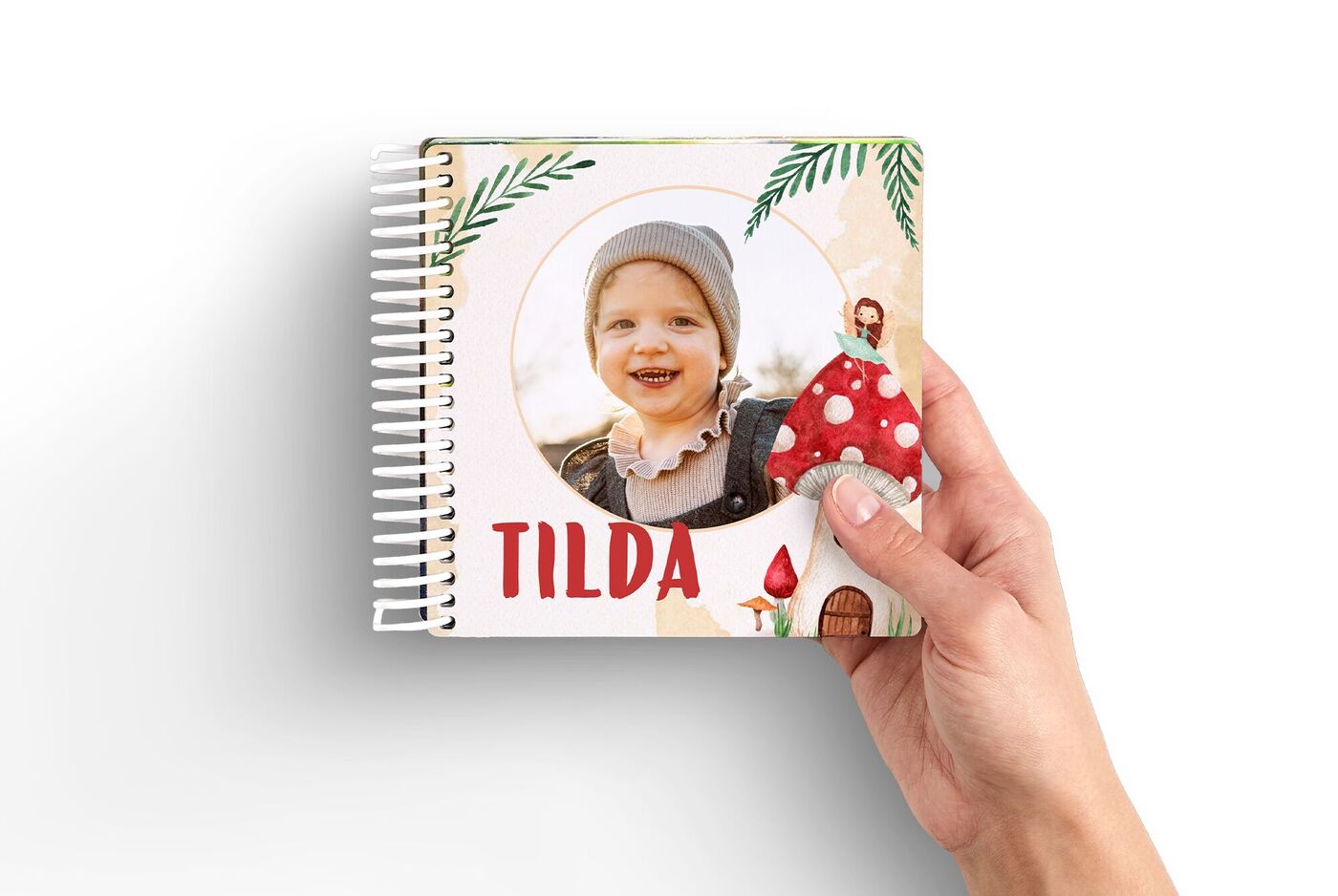 Hand hält personalisiertes CEWE Fotobuch mit Kinderbild und Märchenmotiv
