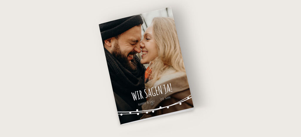 Ein liebevoll gestaltetes Hochzeitsfotobuch mit dem Titel 'Wir sagen Ja!' auf einem neutralen Hintergrund.