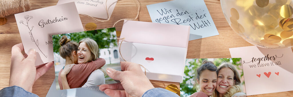 Zwei Personen genießen gemeinsame Erinnerungen mit Fotos und Grußkarten.