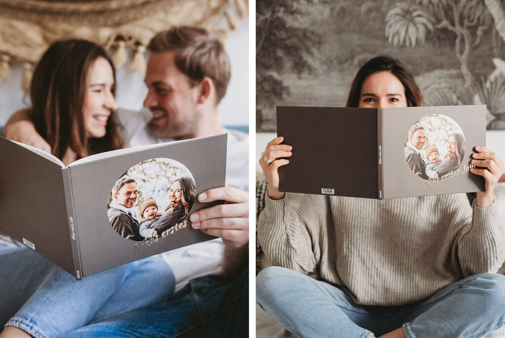 Ein Paar betrachtet ein Fotobuch auf einer gemütlichen Couch.