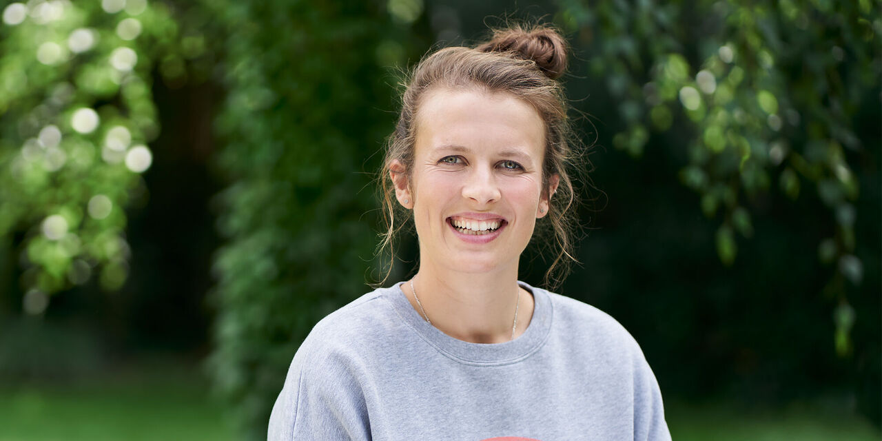 Eine Frau sitzt entspannt im Freien und genießt die Natur.