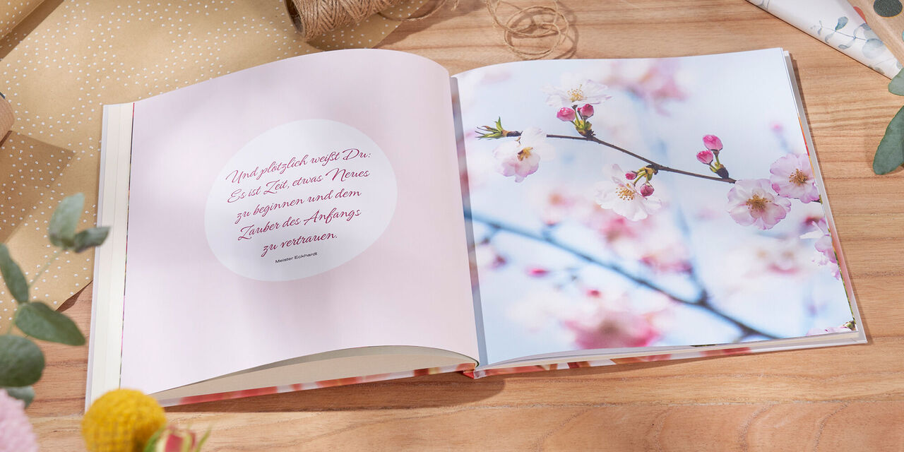 Geöffnetes CEWE Fotobuch mit einer Seite, die eine Kirschblüte zeigt