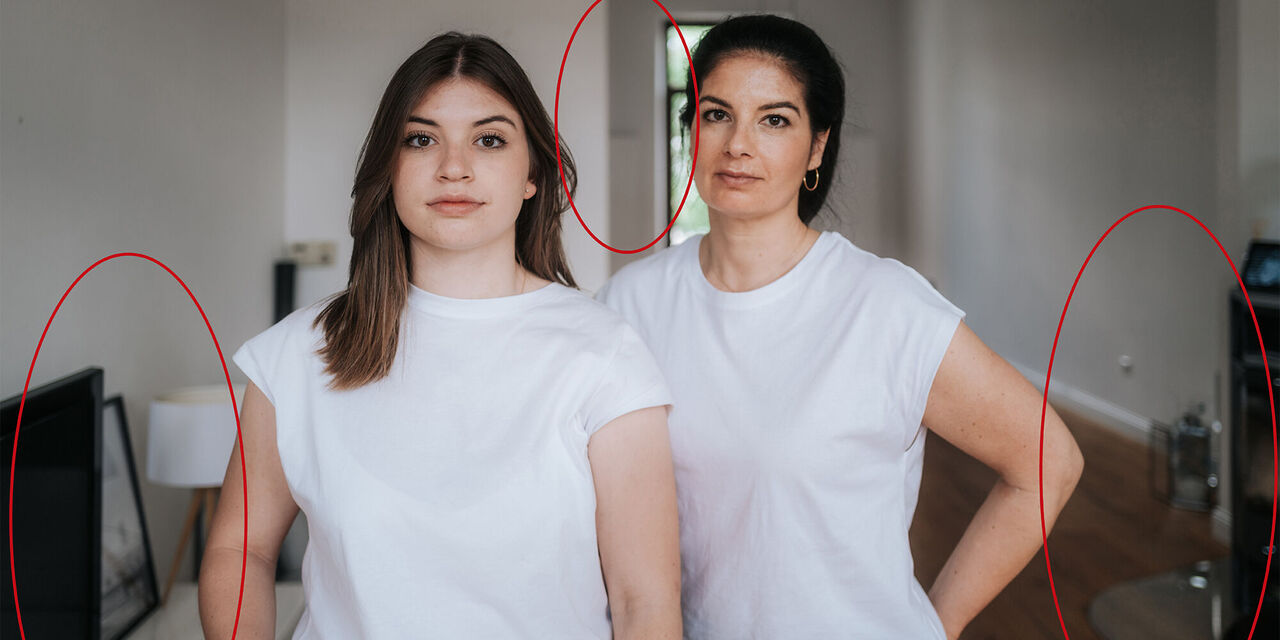 Zwei Frauen in weißen T-Shirts stehen lächelnd in einem hellen Raum. Sie verbinden Freude und Freundschaft.