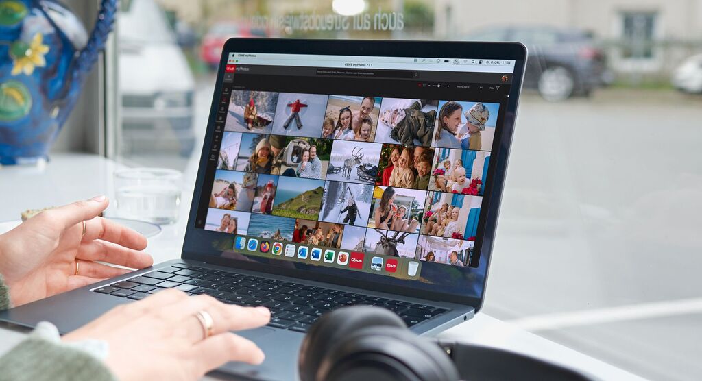 Eine Person schaut auf einen Laptop mit einer Übersicht von Fotos, darunter Erinnerungen und Schnappschüsse.