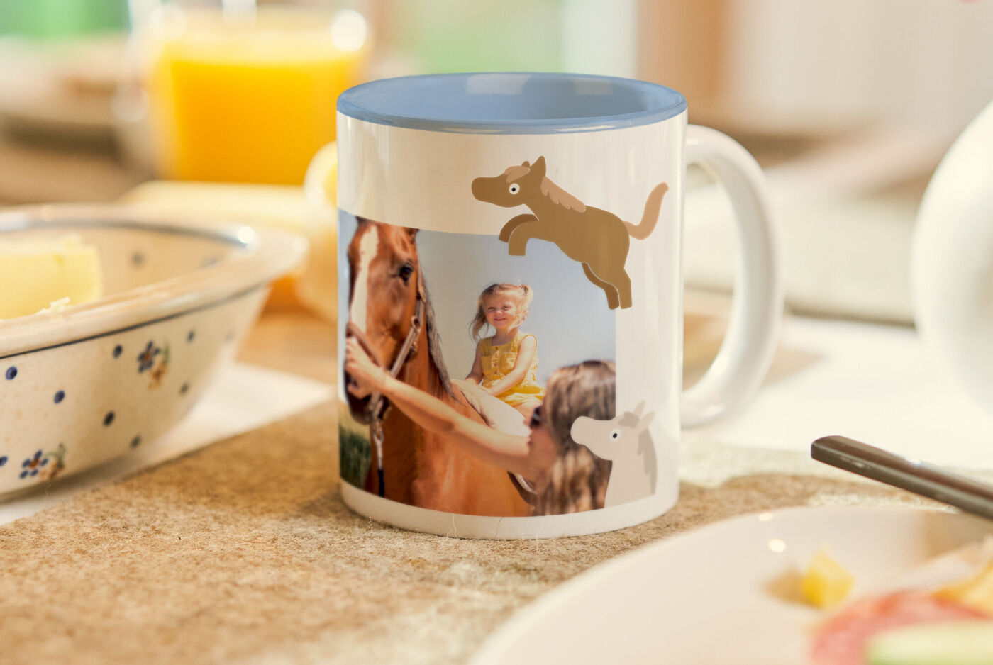 Eine bedruckte Tasse mit Tiermotiven und einem Foto steht auf einem Frühstückstisch.