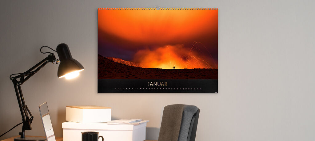 Ein CEWE Fotokalender zeigt einen beeindruckenden Sonnenuntergang im Januar mit zwei Figuren im Silhouetten-Stil.