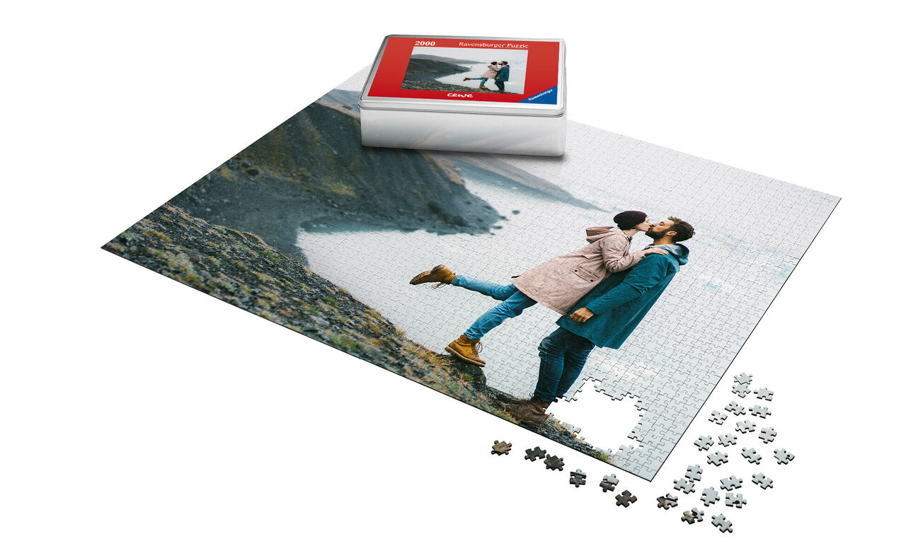 Pärchen küsst sich vor einer Küstenlandschaft auf einem Puzzle.