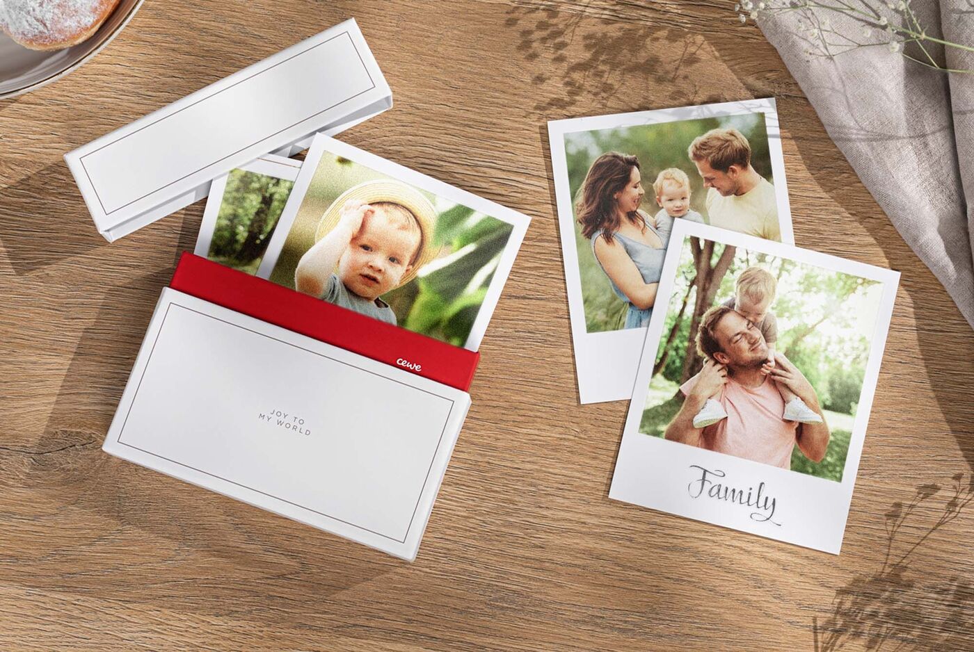 Zwei Fotokarten mit liebevollen Momenten der Familie auf einem Holztisch
