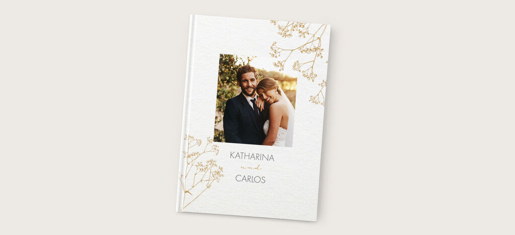 Elegantes Fotobuch mit floralem Design für eine Hochzeit. Namen auf dem Cover: Katharina und Carlos.