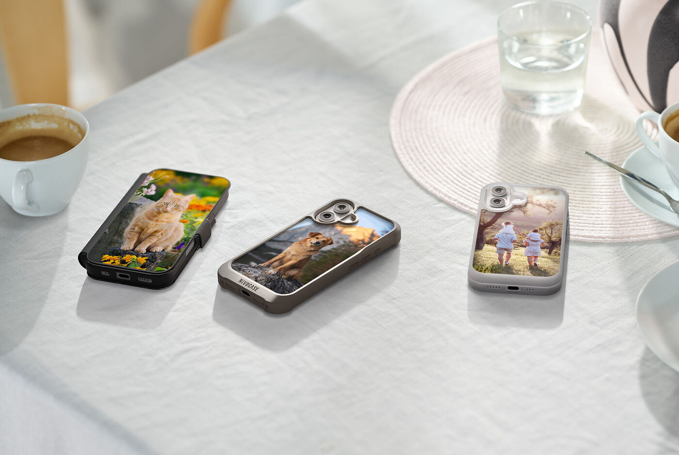 Drei Smartphone‑Hüllen liegen auf einem Tisch und zeigen persönliche Fotos mit Tier‑ und Familienmotiven