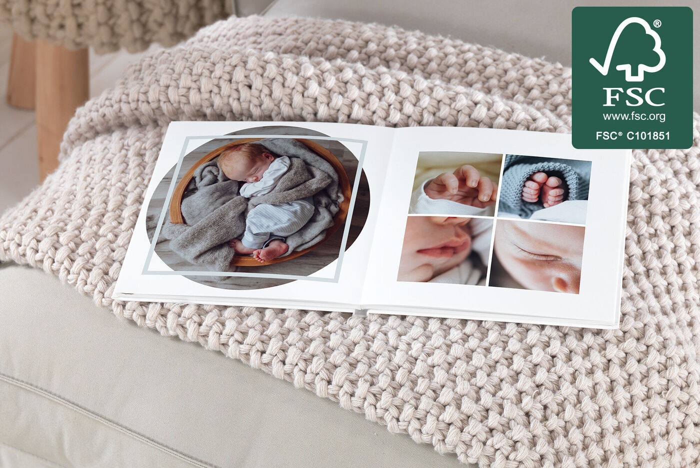Ein offenes Fotobuch auf einer weichen Decke, das Fotos eines Neugeborenen zeigt.