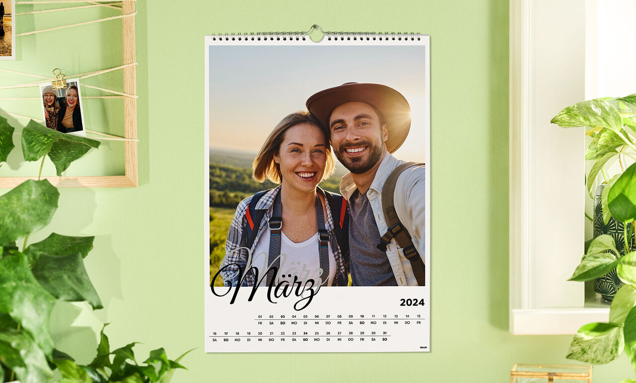 Ein Wandkalender für März 2024 mit einem romantischen Schnappschuss von zwei Personen vor einer grünen Landschaft