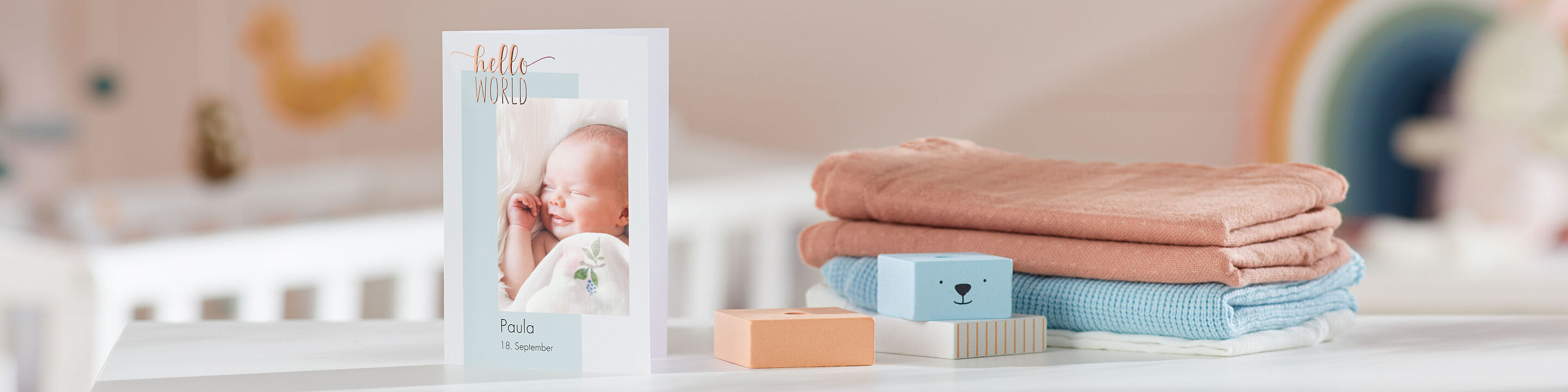 Ein liebevoll gestaltetes Produktfoto zeigt einen hübschen Bilderrahmen mit dem Bild eines Neugeborenen, daneben liegen weiche Babydecken und Spielzeug.
