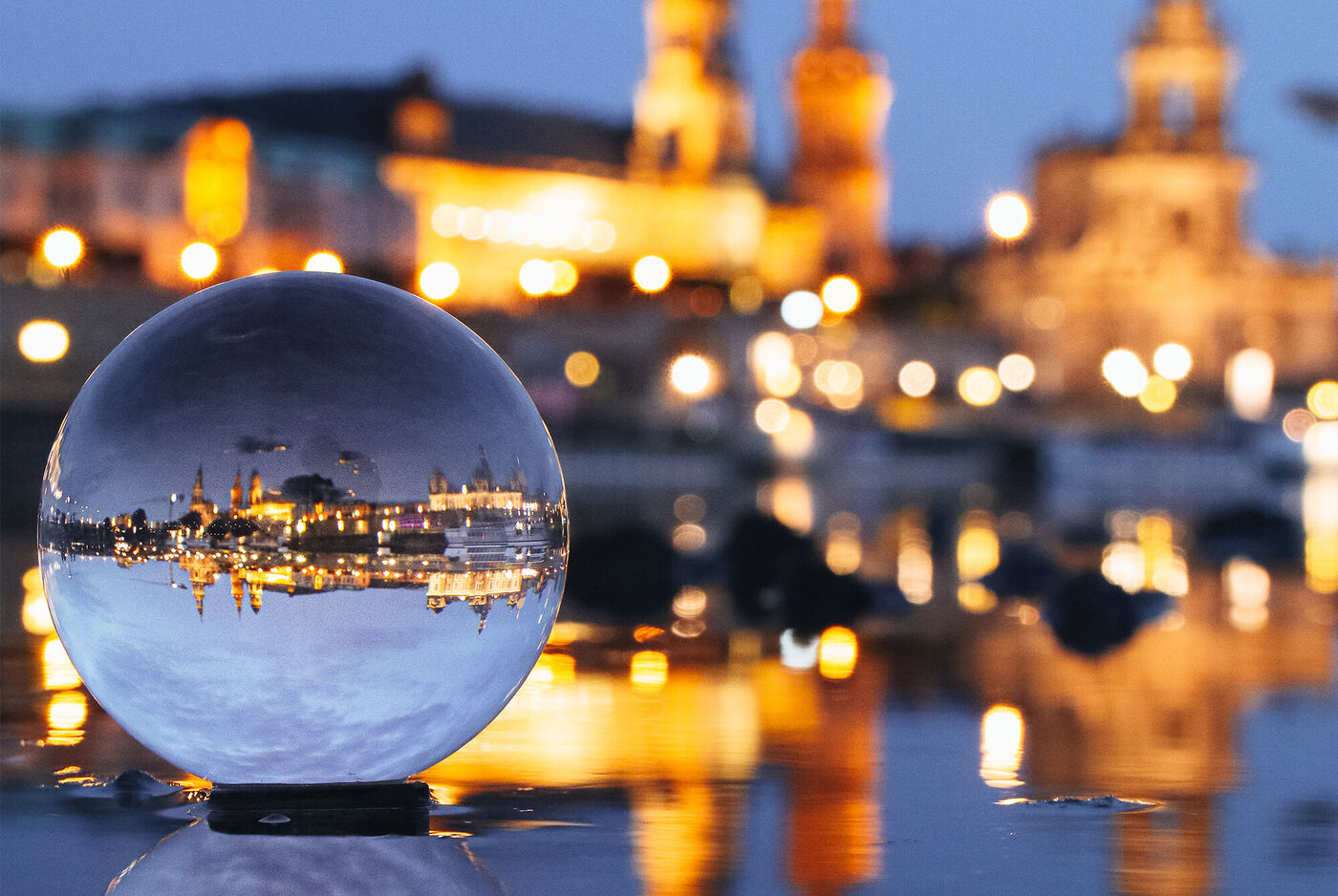 Kristallkugel reflektiert die Lichter einer Stadt bei Nacht
