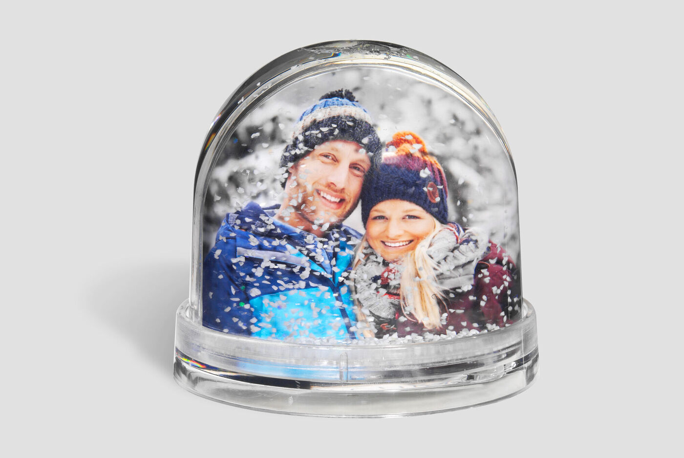 Zwei Personen in einer Schneekugel umgeben von Schneeflocken