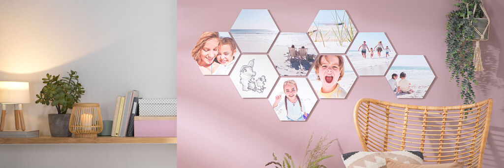 Sechseckige Wandbilder mit fröhlichen Familienmomenten auf zartrosa Wand.