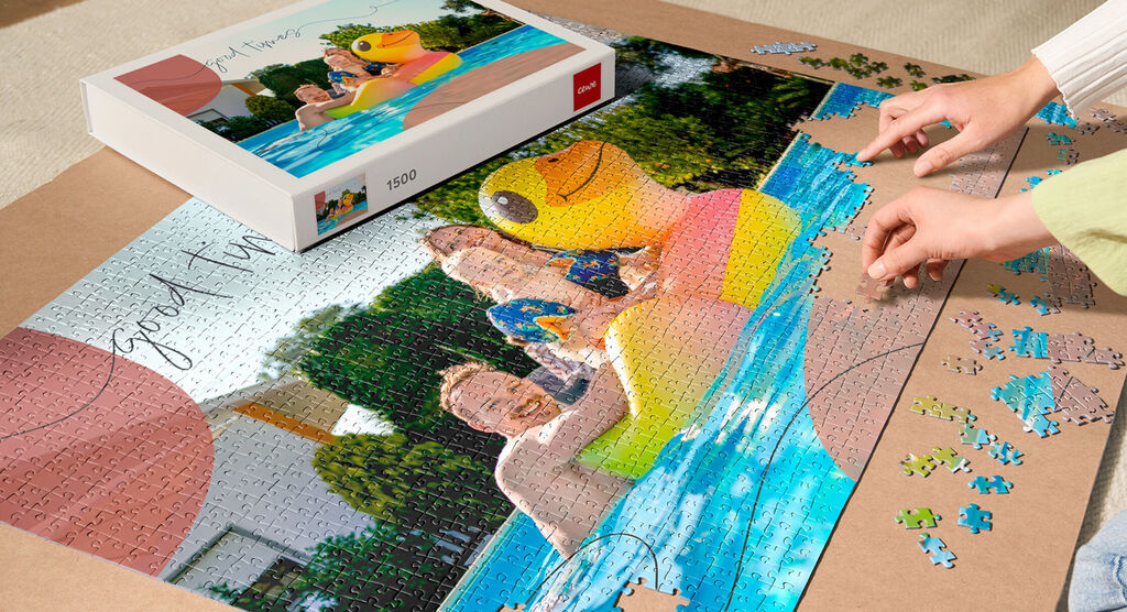 Person arbeitet an einem bunten Puzzle mit Familienmomenten am Pool.