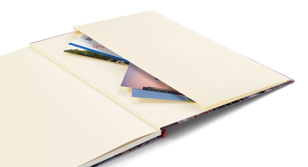 Ein geöffnetes Fotobuch mit leeren Seiten und teilweise liegenden Fotos, die darauf warten, gestaltet zu werden